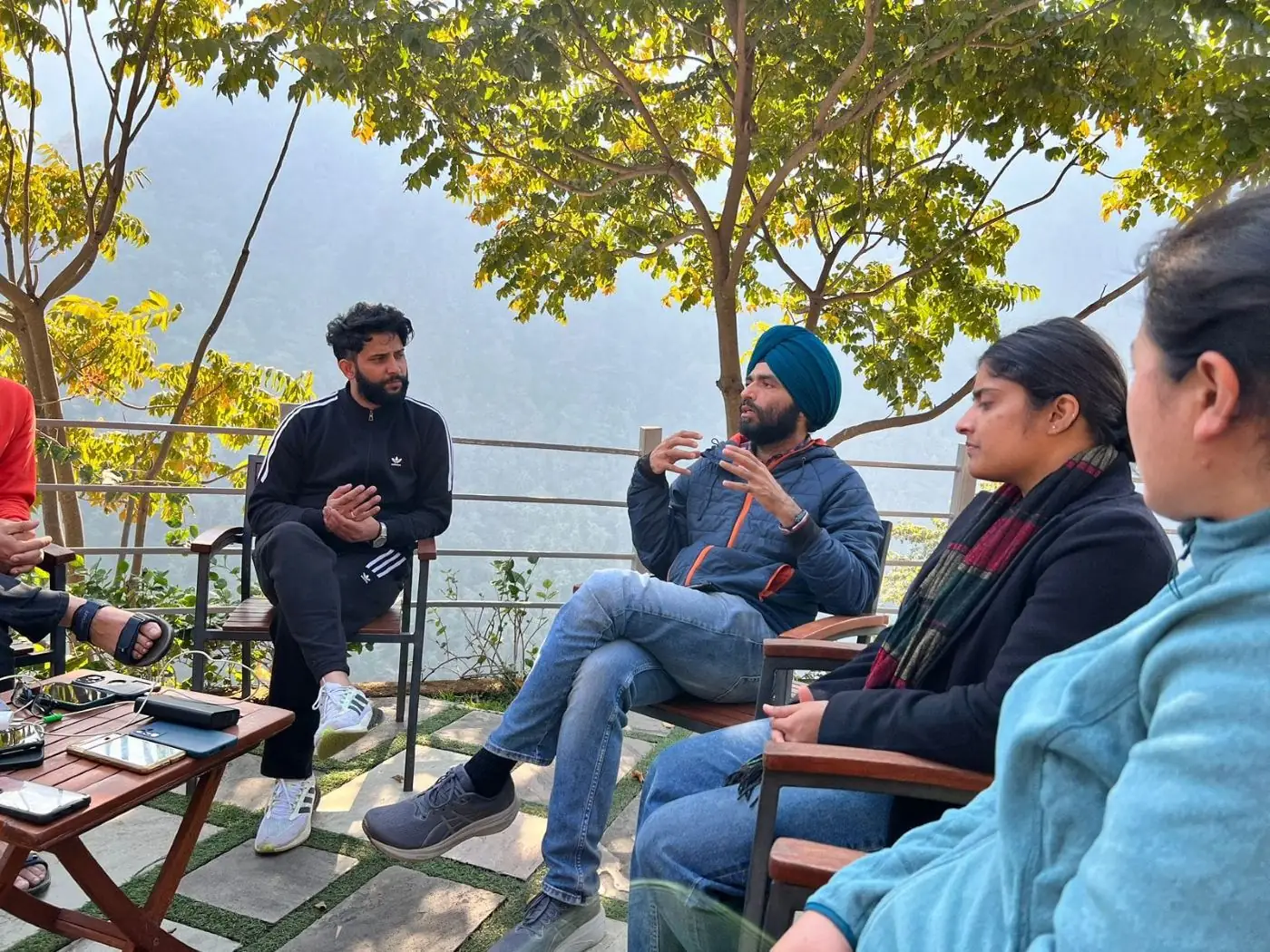 Corporate team in an informal outdoor discussion overlooking the valley at Atali Ganga