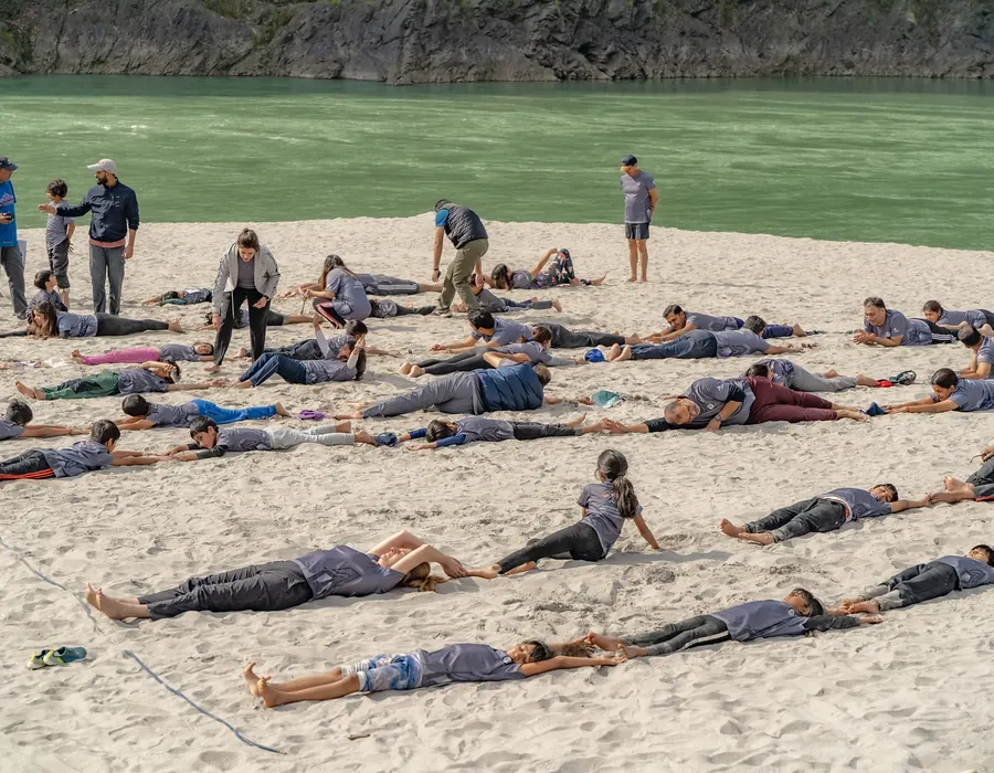 Students stretching together on the riverside sandbar