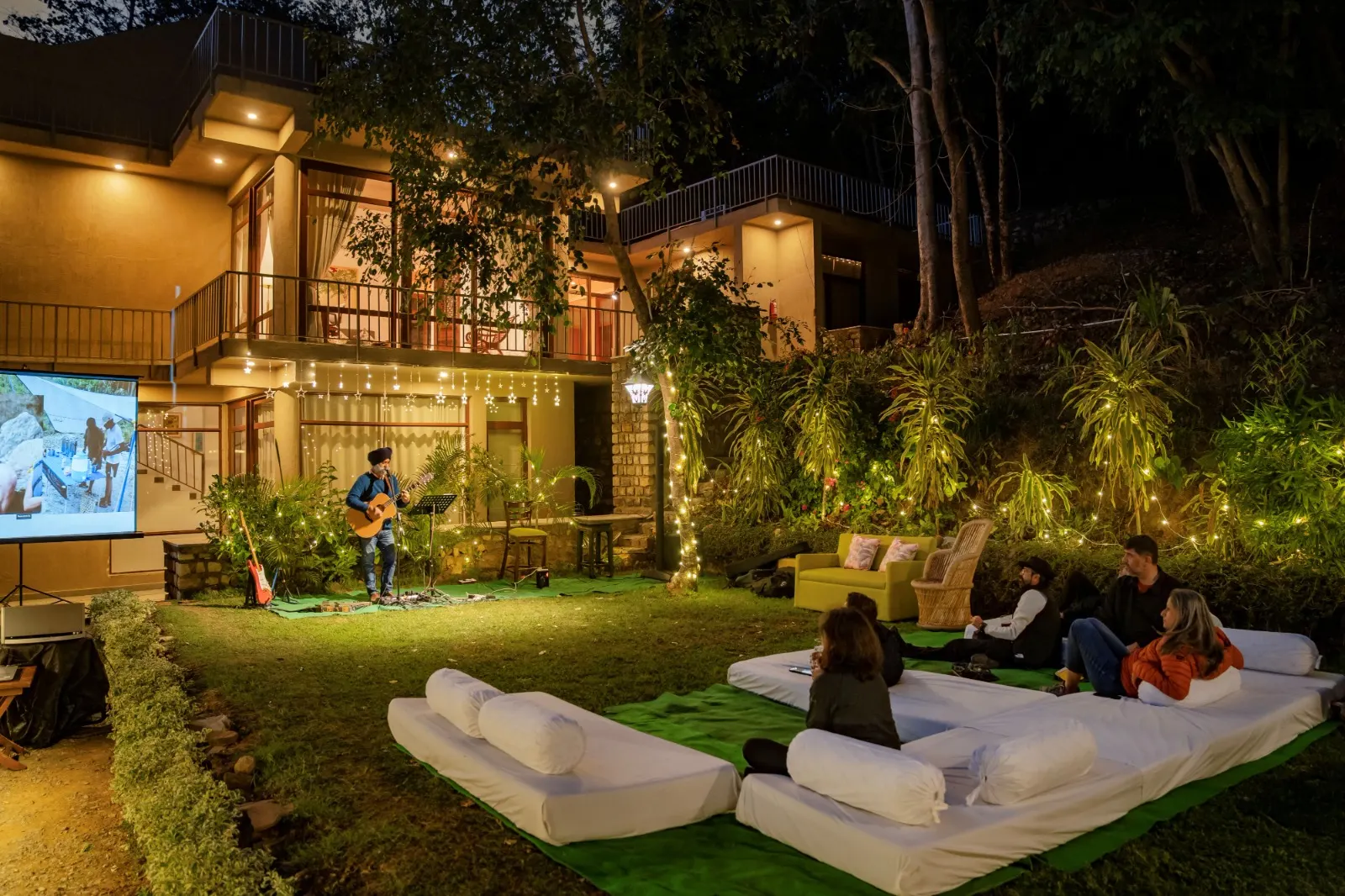 Acoustic guitarist performing live on the lawn at Atali Ganga in the evening