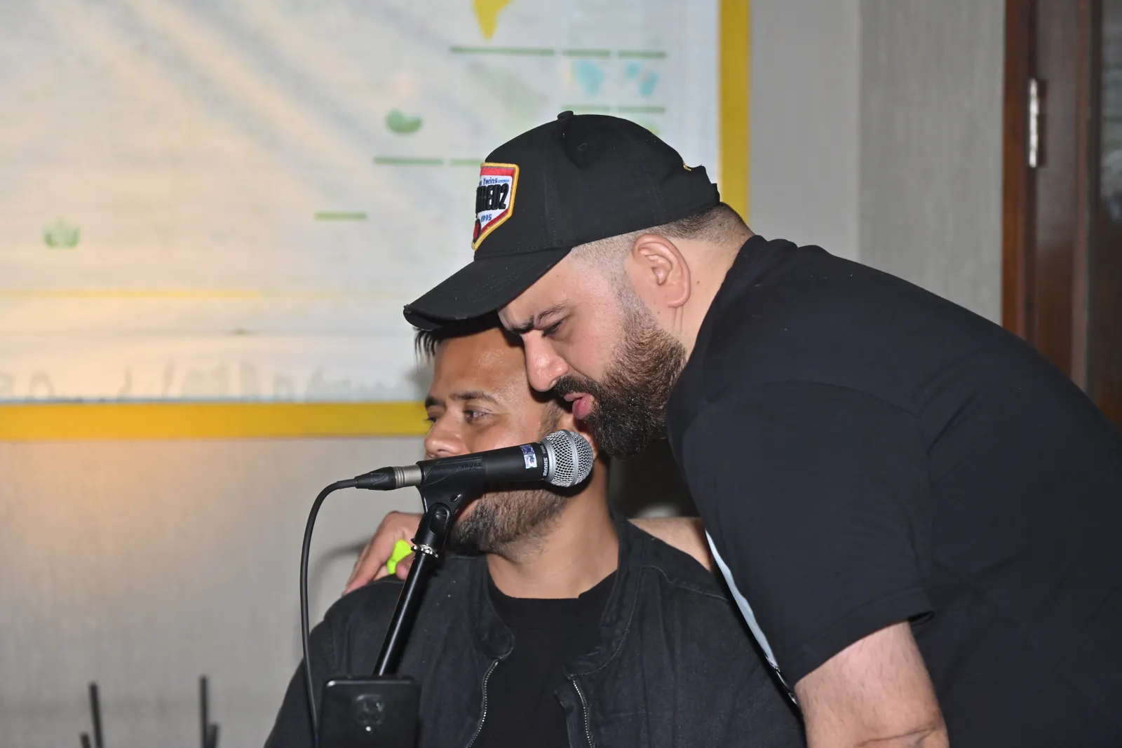 Performers singing live into a microphone at an Atali Ganga event
